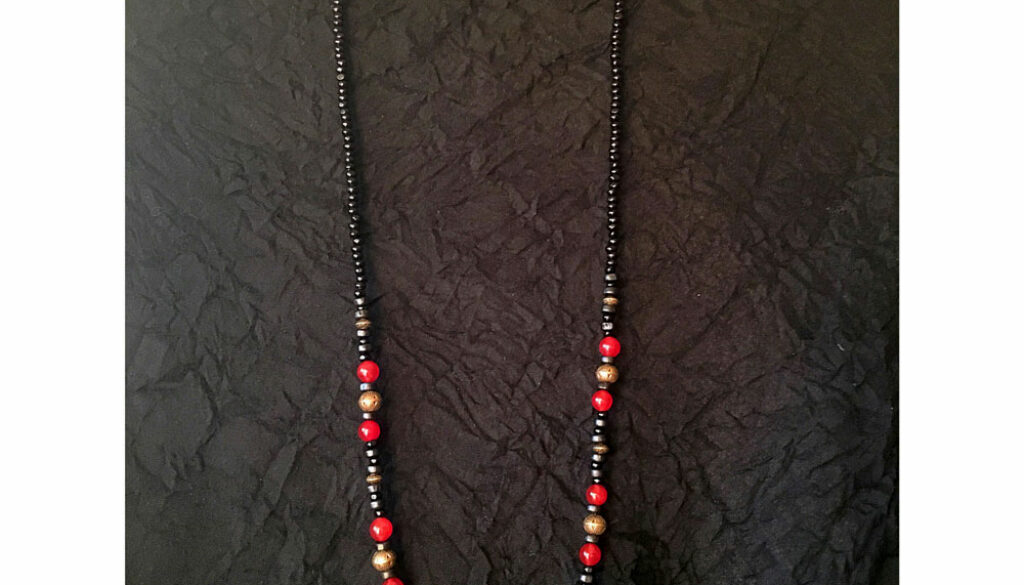 Halsband med svarta träpärlor i olika storlekar, bronsfärgade metallkulor och röda stenpärlor