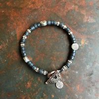 Armband Läderband med svarta keramikpärlor och metalldetaljer.